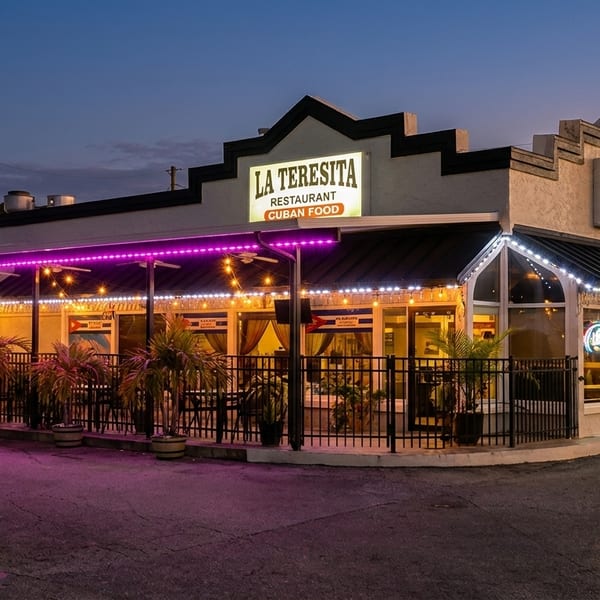 La Teresita Cuban restaurant exterior at dusk, with purple and white string lights illuminating the patio.